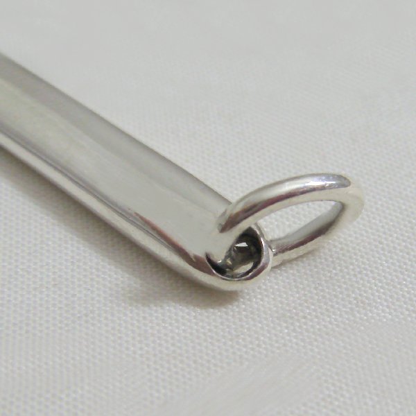 (p1084)Silver pendant in stick form.